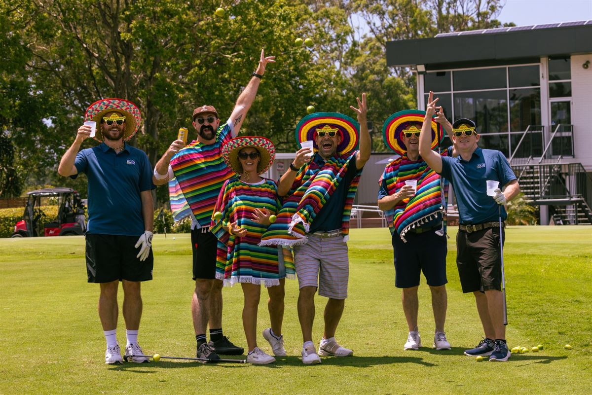 A team in sombreros and ponchos celebrating on the green